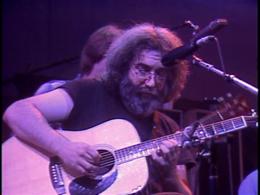 Screenshot of Jerry on acoustic guitar from the Grateful Dead Dead Ahead DVD.